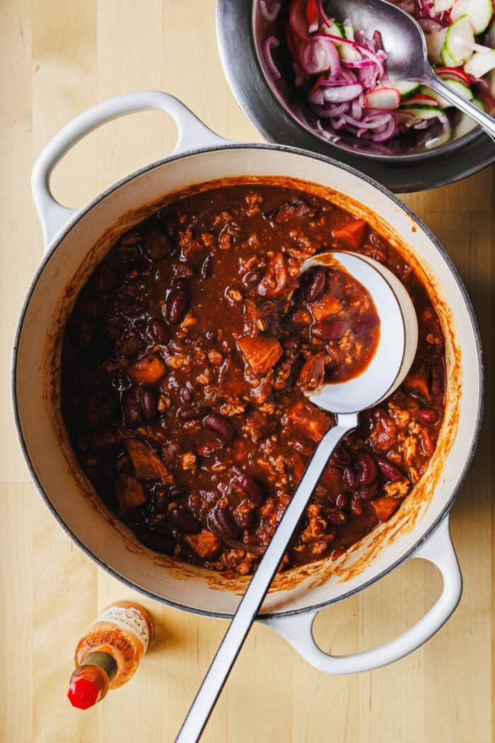 Chili de patate douce végétalien avec haricots rouges et garniture de cornichons