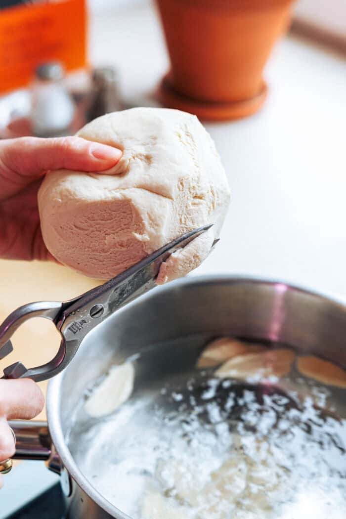 Couper les nouilles aux ciseaux dans l'eau chaude